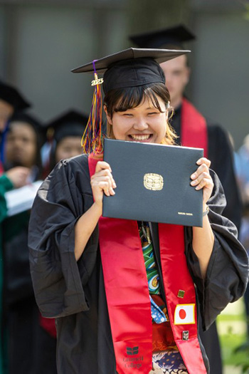A new Grinnell alumnae shows off her diploma. 