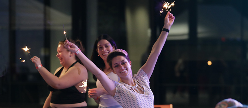 Jade Bustamante '20 celebrates being back with her 2020 classmates by waving sparklers during a reception at Kington Plaza.