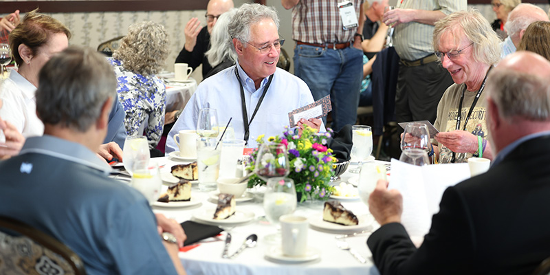 Alumni Award recipient Michael Cullen ’75 reads a conversation card during the 50th Reunion class dinner.