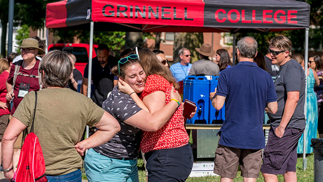 Alumni back for Reunion share a welcoming hug as they greet each other on campus.