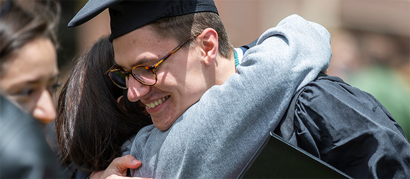 A Grinnell grad hugs a family member at commencement. 