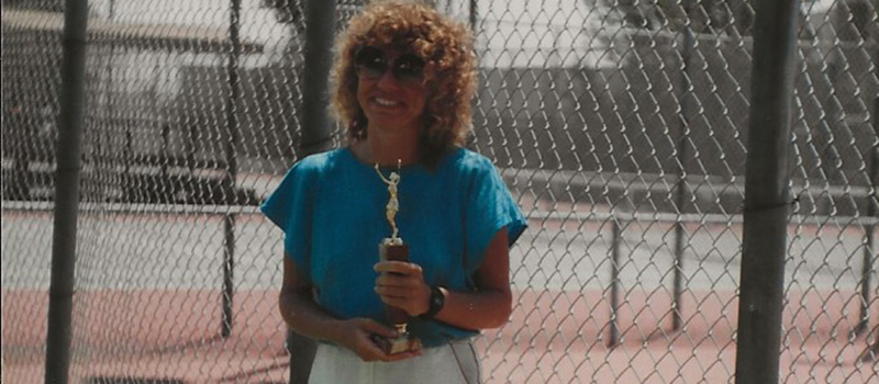 Lorie Hill ’68 poses with a tennis trophy