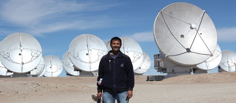 Kartik Sheth ’93 poses in front of several satellite dishes. 