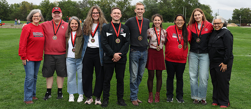 Eight of the 2026 inductees to the Athletic Hall of Fame stand with President Anne F. Harris, left, and Holly Roepke, director of athletics and recreation.