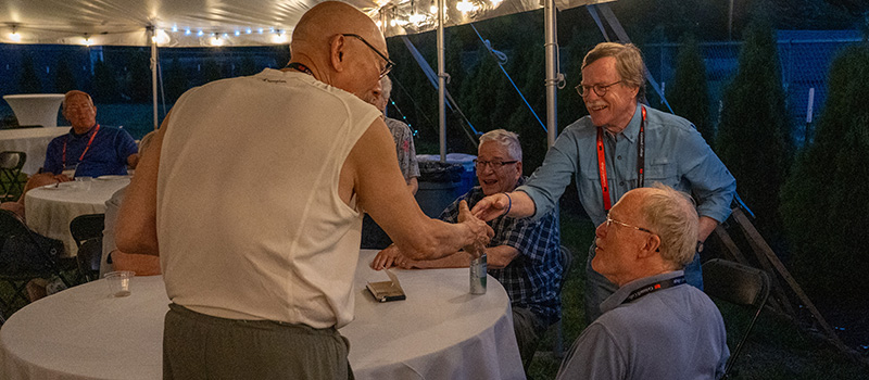 Alums from the 55th reunion cluster (classes of 1968 to 1972) catch up at a welcome event outside Hannah Alumni House.