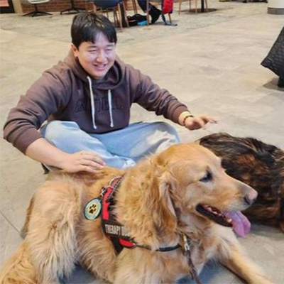 A student takes a moment to reset with a therapy dog. 