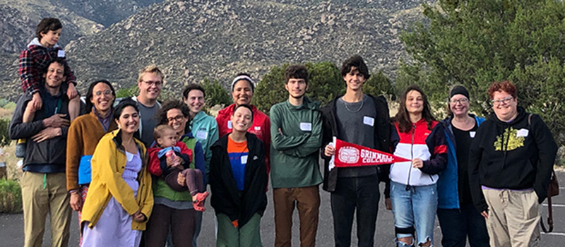Alumni, students, and family members take a group photo June 26 during the Albuquerque Summer Picnic with the Sandia Mountain foothills in the background.