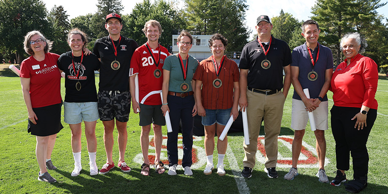 Seven of the new inductees to the Grinnell College Hall of Fame pose for a photo with President Anne F. Harris and Holly Roepke.