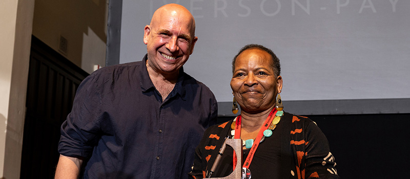 Denise Iverson-Payne ’74, right, is presented with a 2024 Alumni Award from Robert Gehorsam ’76.