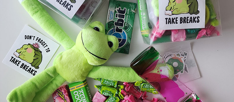 A plush frog, snacks, and stickers to be included in a care package for Grinnell College students. 