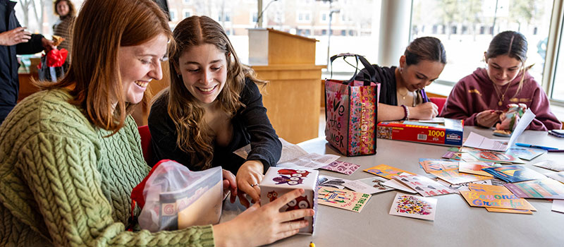 Grinnell students write thank you notes to the alums who sent them care packages.