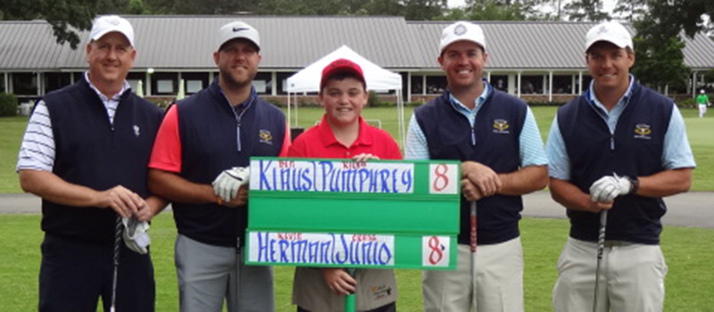 Craig Junio ’90, left, poses with his playing partner and competition following a golf tournament event. 