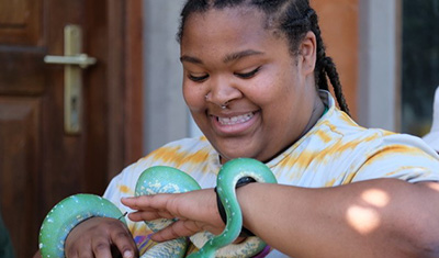 Destant Best ’25 smiles while holding a green snake.