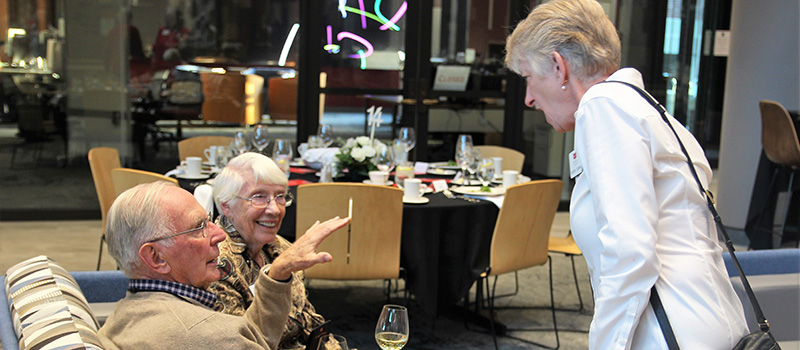 Jo Sunnen Sly ’54 and Skip Sly ’54 chat with Associate Professor Monessa Cummins