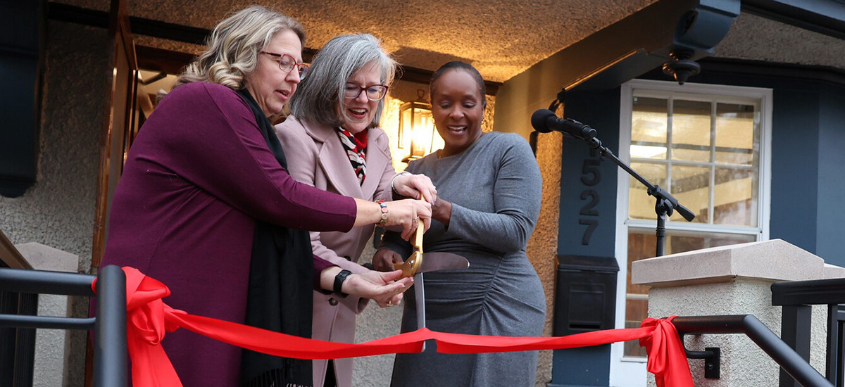Rachel Bly ’93, left, President Anne F. Harris, and Bernadine Douglas cut a red ribbon.