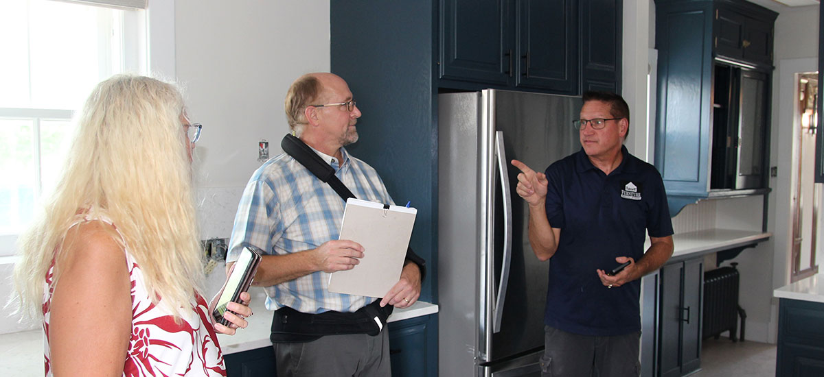 Scott Dean, Rick Whitney, Christi Baker, all chat in the updated kitchen.