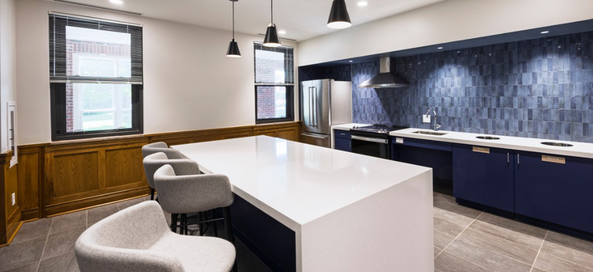 A modern stylized kitchen with blue cabinets, blue backgrounds, and white countertops. 
