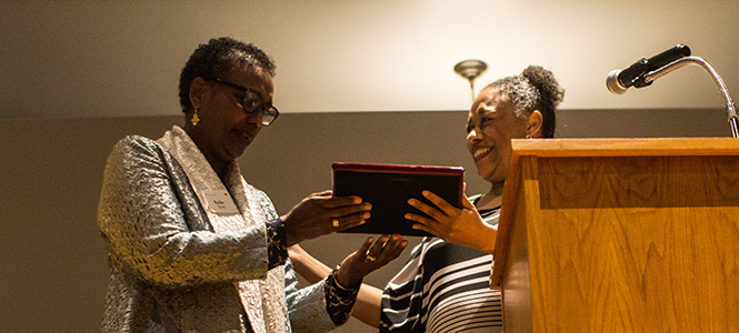 Kesho Scott receiving an award from Lakesha Johnson