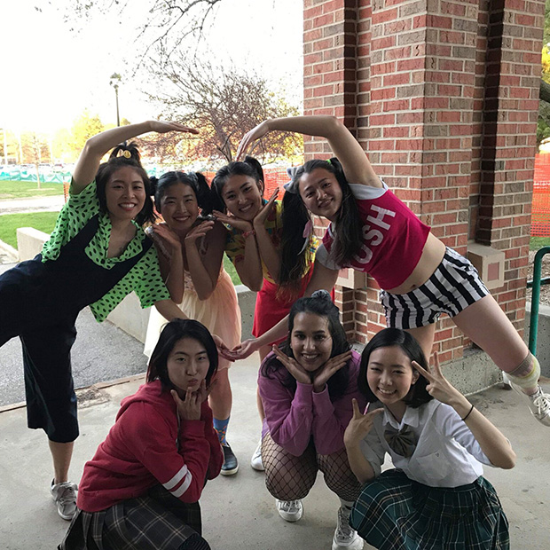A group of asian students pose while working on a dance.