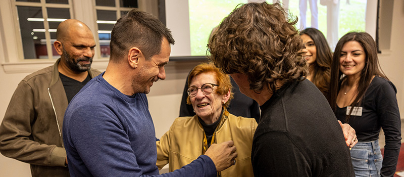 Nancy Schmulbach Maly ‘61 is greeted by former and current international students after the award announcement.