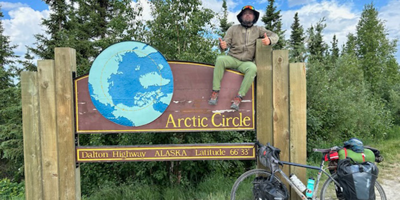 Reed Roffis ’18 poses at a sign along the Dalton Highway in Alaska. 