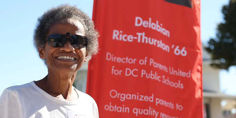 Delabian Rice-Thurston ’66 stands next to her banner.