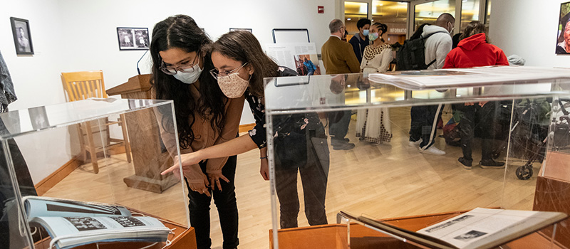 Two attendees examine the True Grinnellian exhibition featuring photos and information about Smith’s life and legacy.