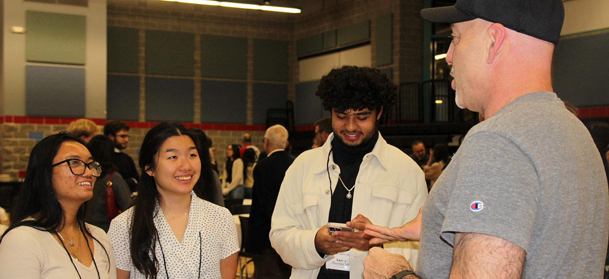 Kaitlyn Thach ’28, left, Amy Tai ’28, and Aarav Sharma ’28 and Alumni Council member David Kurzman ’96.