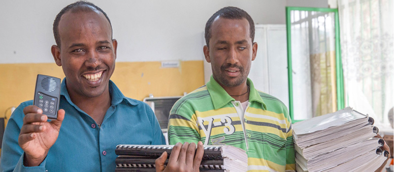 Two blind Ethiopia individuals show off an MP3 player which holds audio text books.