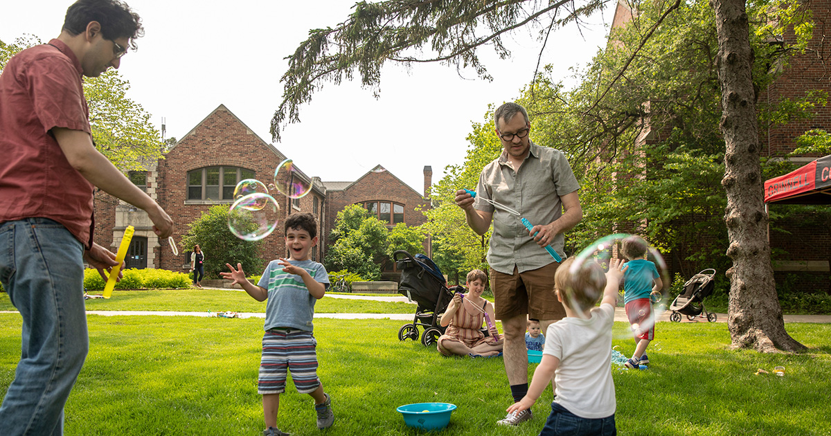 Two dads and their kids play with bubbles during family fun time at Reunion.