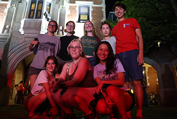 A group of first-year students pose for a photo with Gates-Rawson Tower in backdrop.