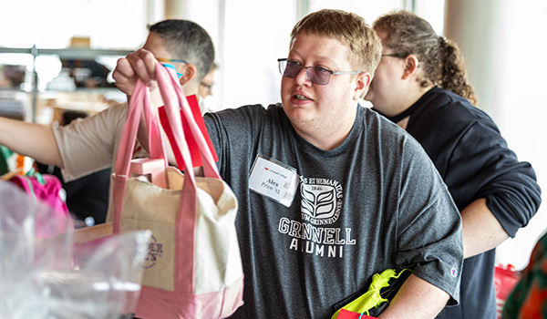 Alex Price &rsquo;15 hands a student a care packages.