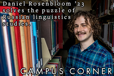 Text: Campus Corner - Daniel Rosenbloom ’23 solves the puzzle of Russian linguistics studies. Image: Daniel Rosenbloom ’23 sits among the rows of the library.