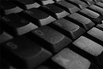 Black and white photo of a laptop keyboard taken zoomed in. 