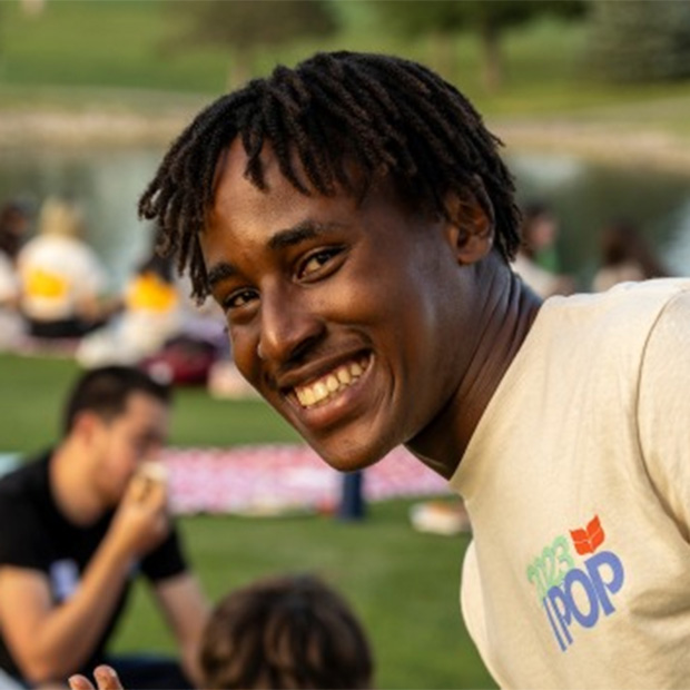 A student smiles and poses for a picture during an outdoor session during  International Pre-Orientation Program (IPOP).