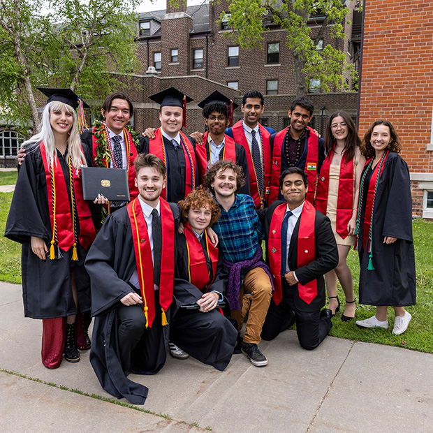 A group of graduates pose for a group photo after Commencement 2022.