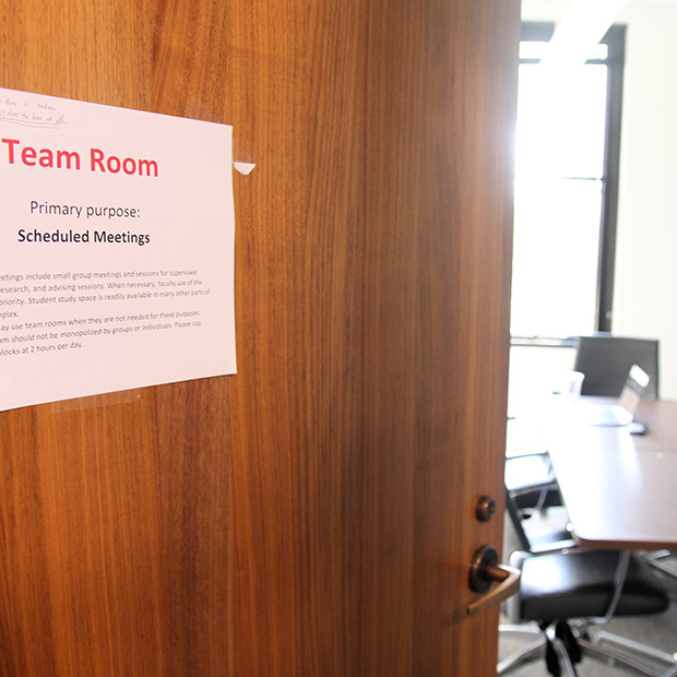 A door in the HSSC to the Gwenna Ihrie team room with a table and chairs in the background.