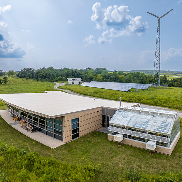 The main building at CERA featuring solar panels and a wind turbine.
